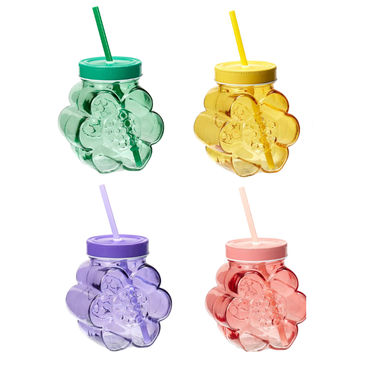 Four flower-shaped transparent plastic drinking jars with screw lids and straws in green, yellow, purple and coral on a white background