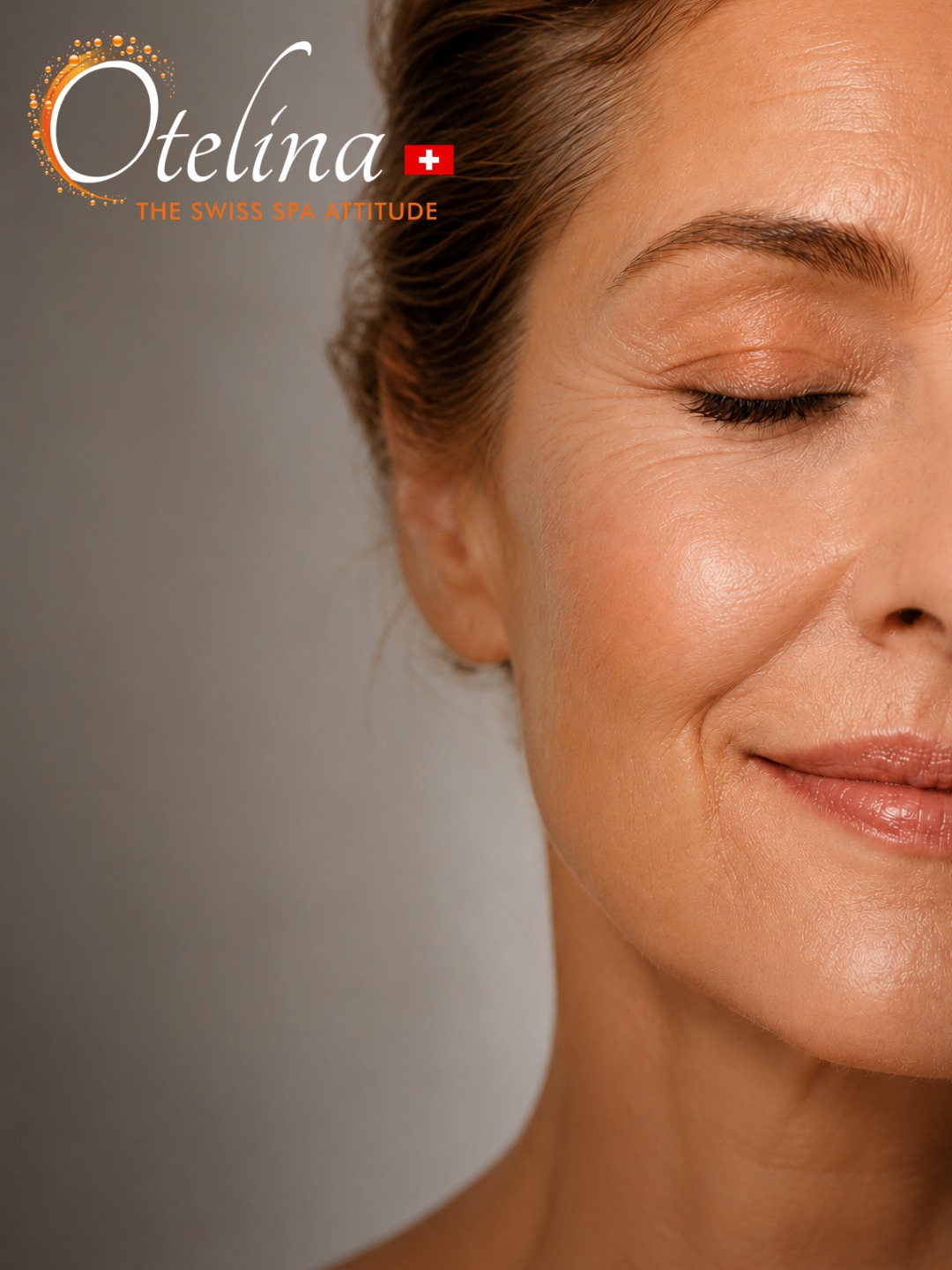 Close-up of a relaxed middle-aged woman's smiling face with eyes closed and natural skin texture; Otelina Swiss Spa logo top-left