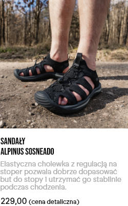 Pair of black Alpinus Sosneado hiking sandals on feet standing on a woodland dirt path, close-up view for outdoor walking.