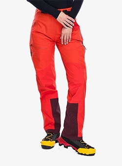 Red women's waterproof hiking trousers with reinforced lower-leg panels and side pockets, shown with yellow walking boots
