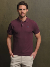 Imagen de modelo con polo basico burgundy con fondo verde