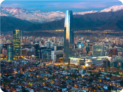 Santiago, Chile skyline at dusk with Gran Torre Santiago skyscraper, city lights and snow-capped Andes mountains in background