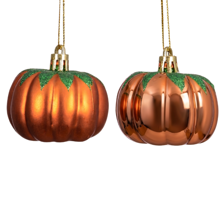 Two copper pumpkin-shaped Christmas baubles with green glitter tops hanging from gold cords on a white background