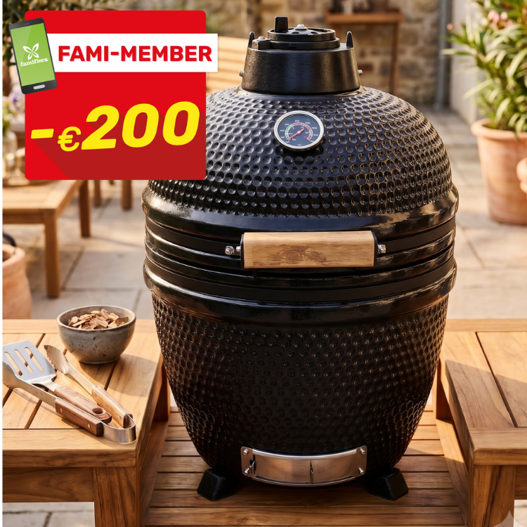 Black kamado ceramic BBQ with thermometer on wooden patio table, tongs and wood chips, red -€200 tag