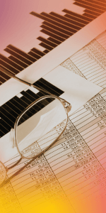 Magnifying glass over financial spreadsheets and a bar chart, close-up of data analysis and accounting figures