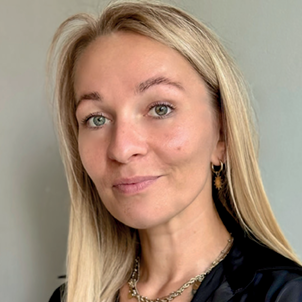 Professional headshot of a smiling blonde woman with green eyes, gold hoop earring and black top